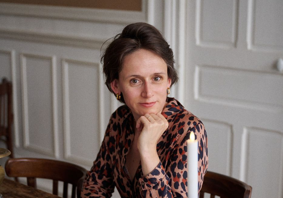 Margaux Pelen at the Tandem dinner table in Paris, a candle beside her