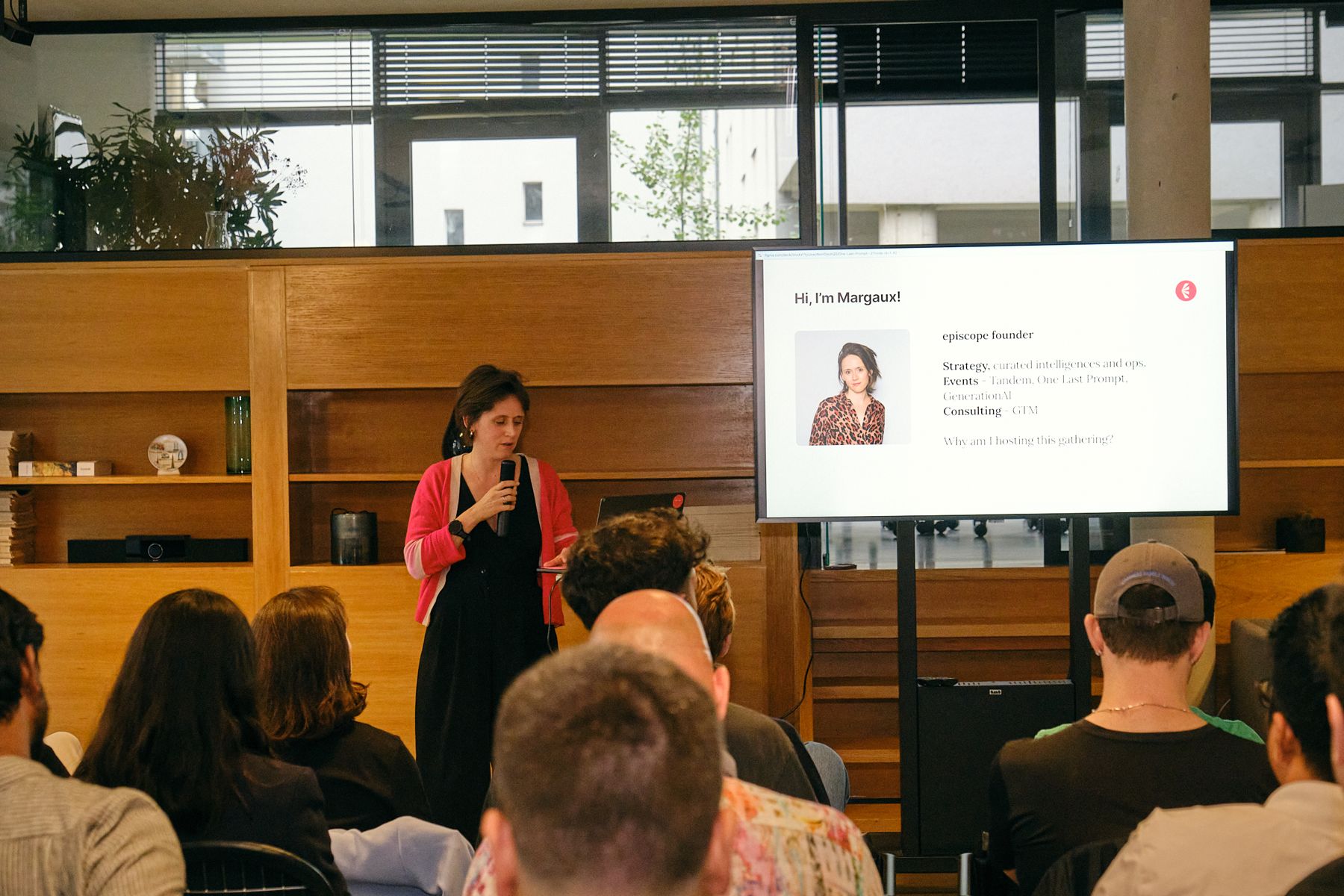 Margaux Pelen speaking beside her slide, the audience in the foreground, at One Last Prompt 2 in Berlin